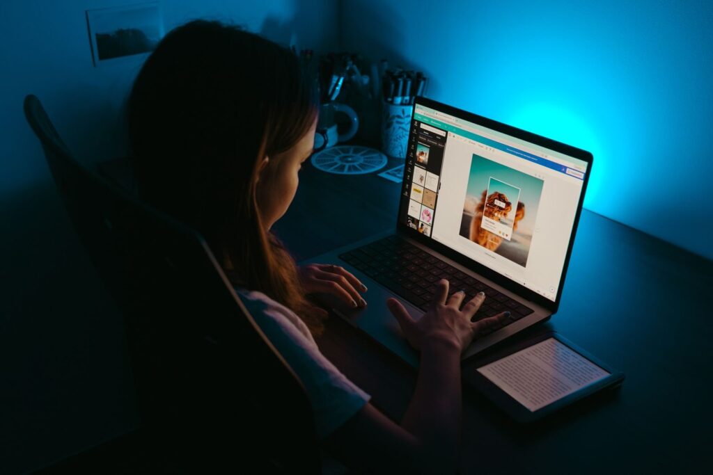 Mujer investigando en el portátil de noche con luz azul