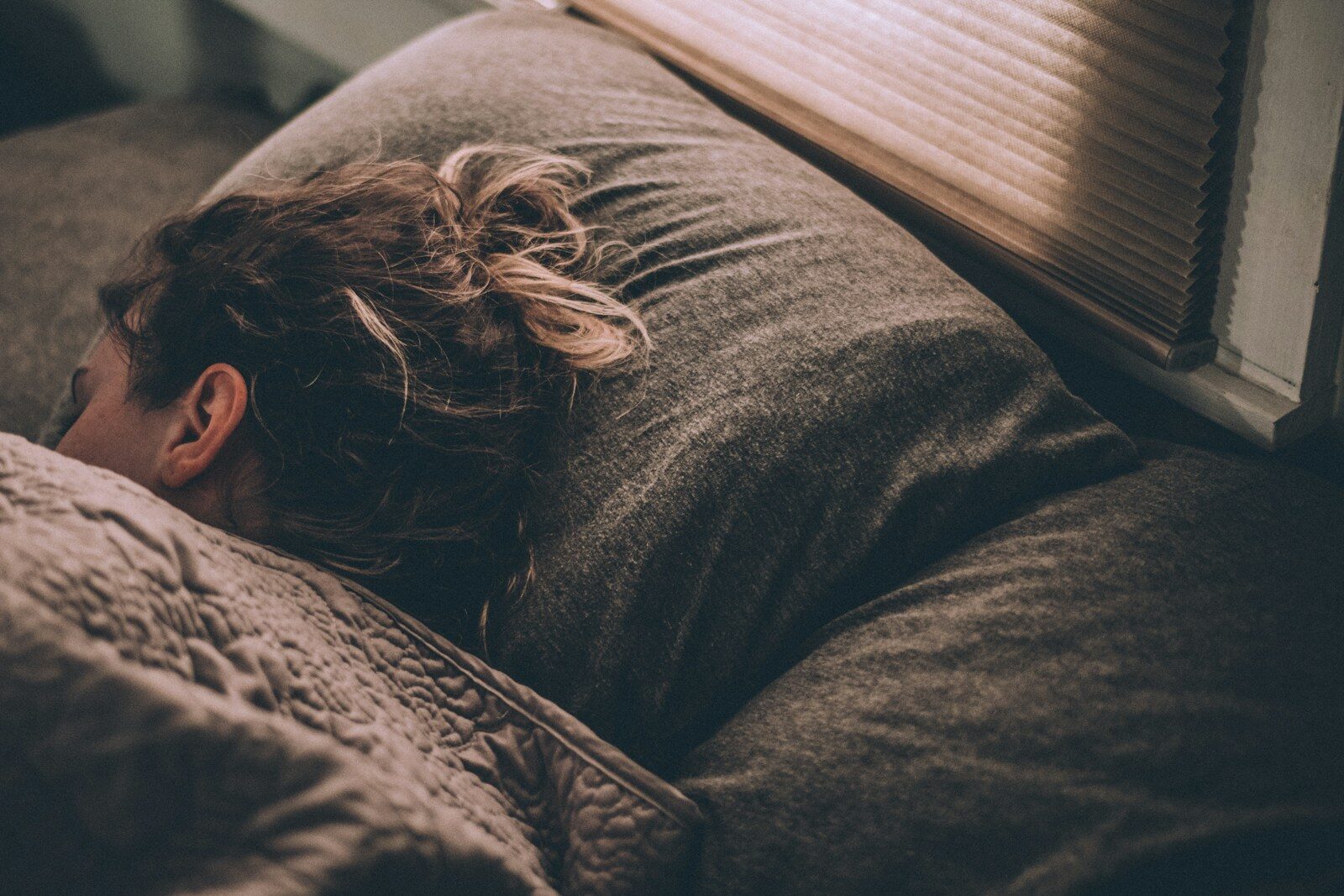 Mujer descansando envuelta en una manta, en un momento de calma y contención emocional