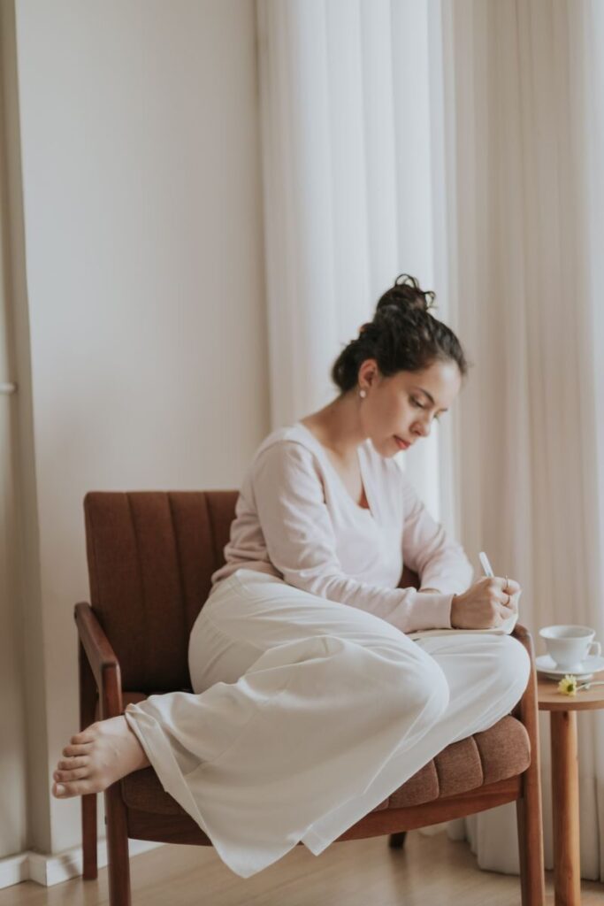 Mujer escribiendo en un diario en un ambiente tranquilo, procesando sus emociones con calma