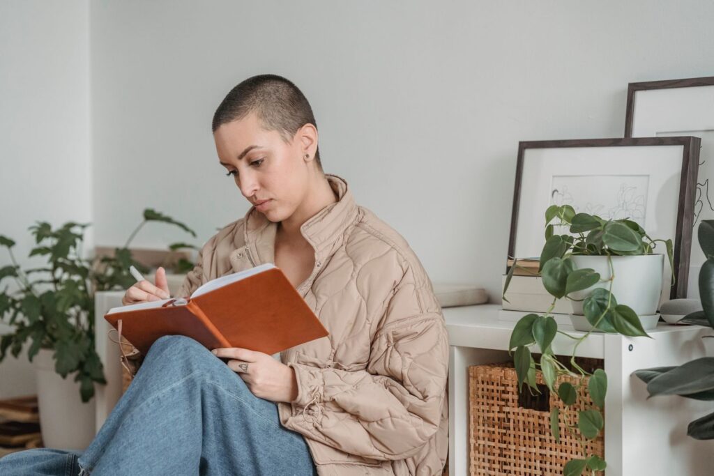Persona leyendo con calma junto a plantas, en un momento de crecimiento personal