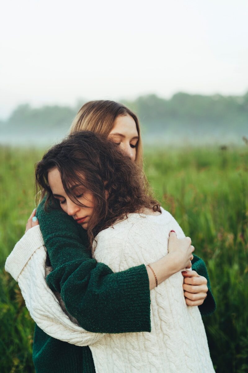 Dos personas abrazándose en un campo, transmitiendo la calidez y contención emocional que esta Luna necesita