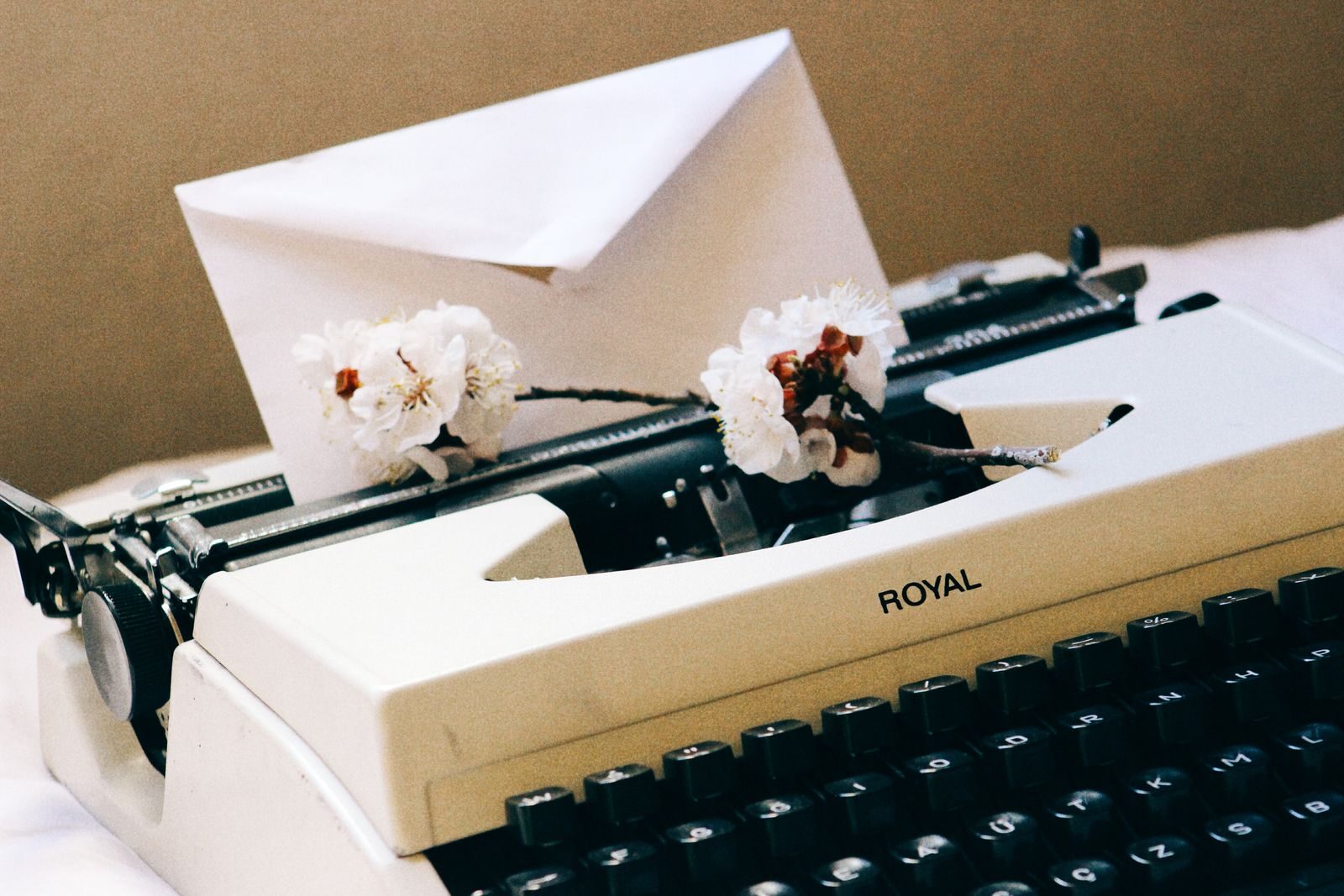 Máquina de escribir antigua con flores de cerezo, símbolo de Mercurio y la comunicación