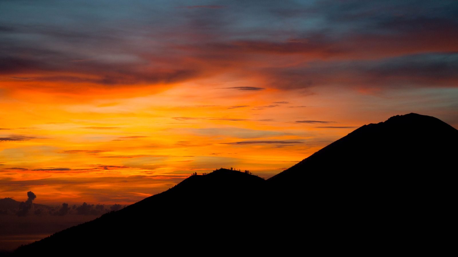 Atardecer vibrante sobre la silueta de una montaña, símbolo del camino evolutivo