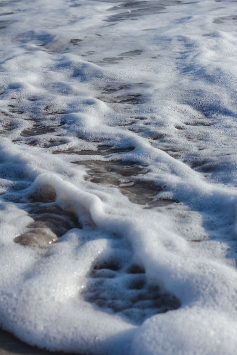 Espuma del mar cubriendo la arena de la playa, símbolo del elemento agua