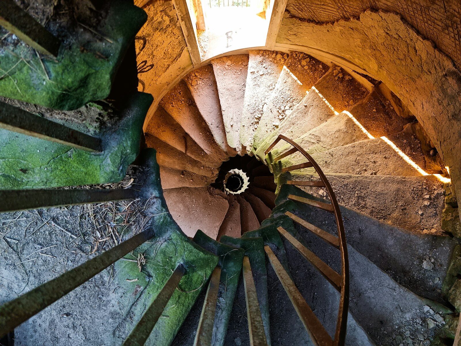 Escalera de piedra en espiral vista desde arriba, símbolo de estructura y tiempo.