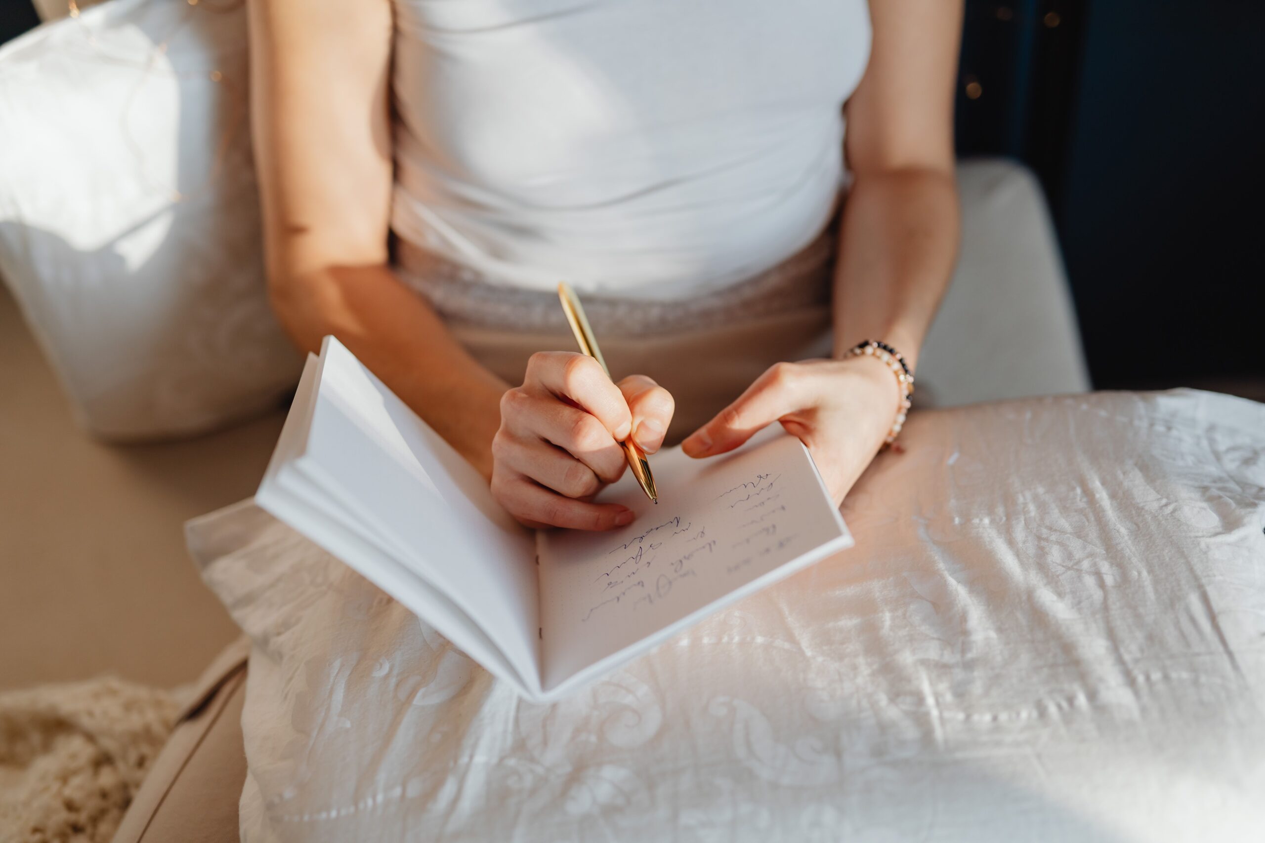 Mujer escribiendo en un diario por la mañana, práctica de journaling para el autoconocimiento